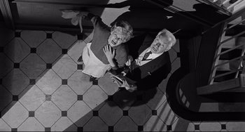 Movie still from “Days of Wine and Roses” (1962), directed by Blake Edwards – An older man and woman standing on a tiled floor; Medium shot, Overhead angle
