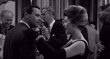 Movie still from “Days of Wine and Roses” (1962), directed by Blake Edwards – A black and white photo of a group of people at an event; Medium shot, Over the shoulder angle
