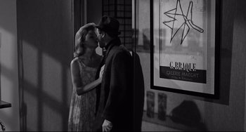 Movie still from “Days of Wine and Roses” (1962), directed by Blake Edwards – A man and a woman kissing in front of a window; Medium shot, Over the shoulder angle