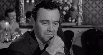 Movie still from “Days of Wine and Roses” (1962), directed by Blake Edwards – A man in a suit and tie sitting in front of a table; Close Up shot, High angle
