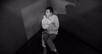 Movie still from “Days of Wine and Roses” (1962), directed by Blake Edwards – A man sitting on the ground in a room; Medium shot, High angle