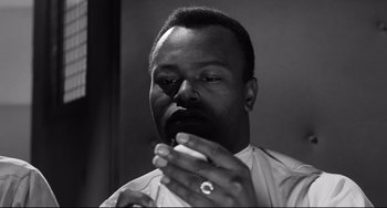 Movie still from “Days of Wine and Roses” (1962), directed by Blake Edwards – A black and white photo of a man smoking a cigarette; Close Up shot, Low angle