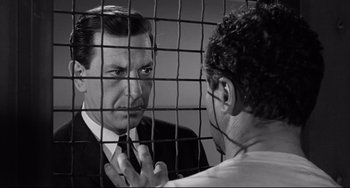 Movie still from “Days of Wine and Roses” (1962), directed by Blake Edwards – A man in a suit and tie looking at another man in a white shirt; Close Up shot, Low angle