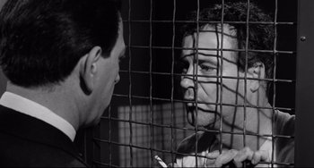 Movie still from “Days of Wine and Roses” (1962), directed by Blake Edwards – Two men are in a cage looking at each other; Close Up shot, Low angle