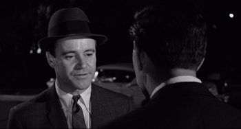 Movie still from “Days of Wine and Roses” (1962), directed by Blake Edwards – A man wearing a suit and a hat talking to another man in a suit; Close Up shot, Over the shoulder angle