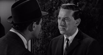 Movie still from “Days of Wine and Roses” (1962), directed by Blake Edwards – A man wearing a suit and tie talking to another man wearing a hat; Close Up shot, Over the shoulder angle