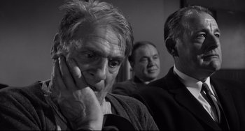 Movie still from “Days of Wine and Roses” (1962), directed by Blake Edwards – Three men in business suits are sitting in front of a wall; Close Up shot, Over the shoulder angle