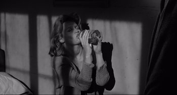 Movie still from “Days of Wine and Roses” (1962), directed by Blake Edwards – A black and white photo of a woman drinking from a cup; Medium shot, High angle