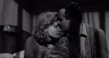 Movie still from “Days of Wine and Roses” (1962), directed by Blake Edwards – A man and a woman kissing while holding a bottle; Close Up shot, Low angle