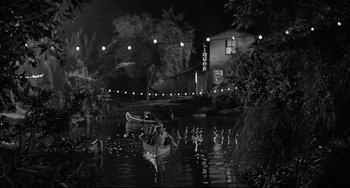 Movie still from “Days of Wine and Roses” (1962), directed by Blake Edwards – A couple of people are in a canoe at night; Extreme Wide shot, High angle