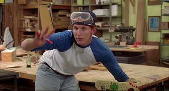 Movie still from “Dazed and Confused” (1993), directed by Richard Linklater – A young man holding a skateboard in a workshop; Medium shot, Low angle