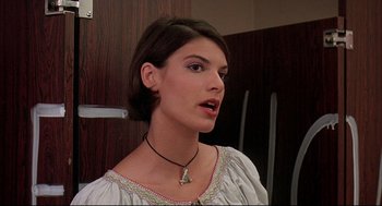 Movie still from “Dazed and Confused” (1993), directed by Richard Linklater – A young woman wearing a white shirt and a black necklace; Close Up shot, Over the shoulder angle