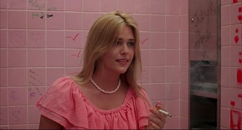 Movie still from “Dazed and Confused” (1993), directed by Richard Linklater – A woman in a pink dress smoking a cigarette in a bathroom; Close Up shot, Over the shoulder angle