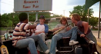 Movie still from “Dazed and Confused” (1993), directed by Richard Linklater – A group of young men sitting in the back of a truck; Wide shot, High angle