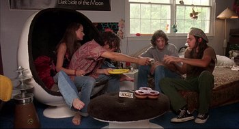 Movie still from “Dazed and Confused” (1993), directed by Richard Linklater – A group of young people sitting around a living room; Wide shot, High angle