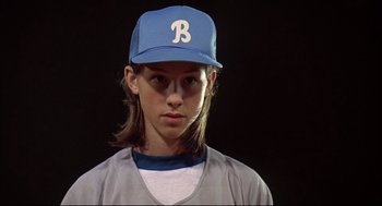Movie still from “Dazed and Confused” (1993), directed by Richard Linklater – A young boy wearing a baseball uniform and a hat; Close Up shot, Low angle