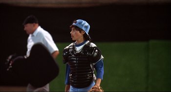 Movie still from “Dazed and Confused” (1993), directed by Richard Linklater – A baseball player wearing a catcher's outfit; Medium shot, Over the shoulder angle