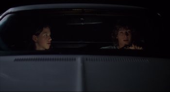 Movie still from “Dazed and Confused” (1993), directed by Richard Linklater – Two people sitting in the back seat of a car; Medium shot, Low angle