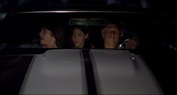 Movie still from “Dazed and Confused” (1993), directed by Richard Linklater – Three people in the back seat of a car at night; Medium shot, Low angle