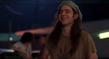 Movie still from “Dazed and Confused” (1993), directed by Richard Linklater – A man with long hair and a hat is smiling; Close Up shot, Low angle