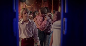 Movie still from “Dazed and Confused” (1993), directed by Richard Linklater – A group of people standing around each other in a room; Medium shot, Over the shoulder angle