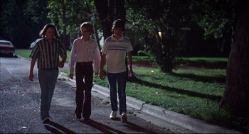 Movie still from “Dazed and Confused” (1993), directed by Richard Linklater – A couple of people that are walking down the street; Wide shot, Low angle