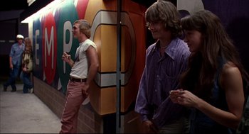 Movie still from “Dazed and Confused” (1993), directed by Richard Linklater – A group of young men standing next to each other; Medium shot, Over the shoulder angle