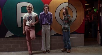 Movie still from “Dazed and Confused” (1993), directed by Richard Linklater – A group of young men standing next to each other in front of a wall; Wide shot, Low angle