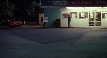 Movie still from “Dazed and Confused” (1993), directed by Richard Linklater – A man standing in front of a store at night; Extreme Wide shot, Low angle