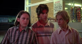 Movie still from “Dazed and Confused” (1993), directed by Richard Linklater – A group of young men standing next to each other; Medium shot, Low angle