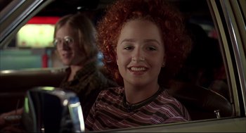 Movie still from “Dazed and Confused” (1993), directed by Richard Linklater – A woman with red curly hair sitting next to another woman; Close Up shot, Low angle