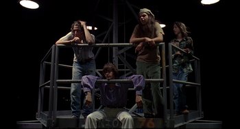 Movie still from “Dazed and Confused” (1993), directed by Richard Linklater – A group of people standing next to each other on a stage; Medium shot, Low angle