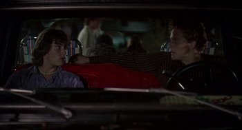 Movie still from “Dazed and Confused” (1993), directed by Richard Linklater – Two people sitting in a car looking out the window; Medium shot, Over the shoulder angle