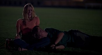 Movie still from “Dazed and Confused” (1993), directed by Richard Linklater – A woman and a boy laying in the grass at night; Medium shot, Low angle