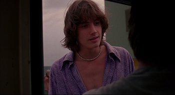 Movie still from “Dazed and Confused” (1993), directed by Richard Linklater – A young man with long hair and a purple shirt; Close Up shot, Over the shoulder angle
