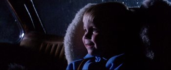 Movie still from “Dead Calm” (1989), directed by Phillip Noyce – A little boy sitting in a chair with a smile on his face; Close Up shot, Low angle
