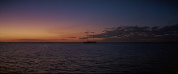 Movie still from “Dead Calm” (1989), directed by Phillip Noyce – A sailboat in the middle of the ocean at sunset; Extreme Wide shot, Low angle
