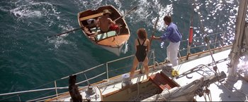 Movie still from “Dead Calm” (1989), directed by Phillip Noyce – A couple of people standing on top of a boat in the water; Wide shot, Overhead angle