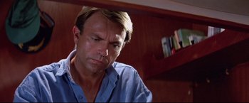 Movie still from “Dead Calm” (1989), directed by Phillip Noyce – A person sitting down looking down; Close Up shot, Low angle