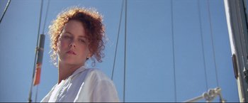 Movie still from “Dead Calm” (1989), directed by Phillip Noyce – A woman with curly hair standing on top of a sailboat; Close Up shot, Low angle