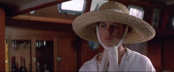 Movie still from “Dead Calm” (1989), directed by Phillip Noyce – A woman wearing a straw hat and a white scarf; Close Up shot, Low angle