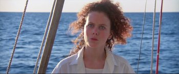Movie still from “Dead Calm” (1989), directed by Phillip Noyce – A woman with curly red hair standing in front of the ocean; Close Up shot, Low angle