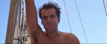 Movie still from “Dead Calm” (1989), directed by Phillip Noyce – A man with a hairy chest and a bare tortoiseshell face; Close Up shot, Low angle