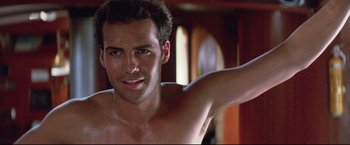Movie still from “Dead Calm” (1989), directed by Phillip Noyce – A man with no shirt is posing for the camera; Close Up shot, Low angle