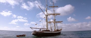 Movie still from “Dead Calm” (1989), directed by Phillip Noyce – A large sail boat sailing in the ocean under a cloudy sky; Extreme Wide shot, Low angle