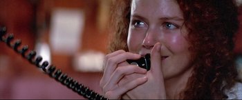 Movie still from “Dead Calm” (1989), directed by Phillip Noyce – A woman holding a phone up to her mouth; Close Up shot, Over the shoulder angle