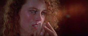 Movie still from “Dead Calm” (1989), directed by Phillip Noyce – A person with curly hair crying; Close Up shot, Over the shoulder angle