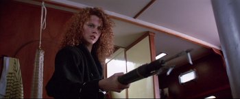 Movie still from “Dead Calm” (1989), directed by Phillip Noyce – A woman holding a gun while wearing a black jacket; Close Up shot, Low angle