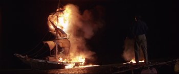 Movie still from “Dead Calm” (1989), directed by Phillip Noyce – A large ship is on fire at night time; Extreme Wide shot, Low angle