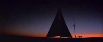 Movie still from “Dead Calm” (1989), directed by Phillip Noyce – A sailboat is silhouetted against the setting sun; Extreme Wide shot, Low angle